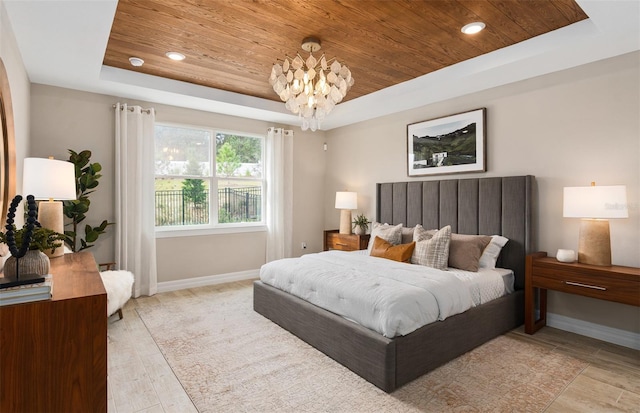 bedroom featuring a tray ceiling, light hardwood / wood-style floors, wood ceiling, and a notable chandelier