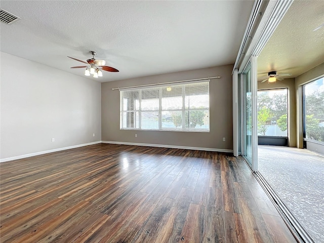 spare room featuring ceiling fan, dark hardwood / wood-style flooring, and a textured ceiling