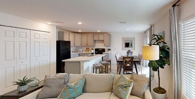 kitchen with black fridge, sink, and a kitchen island