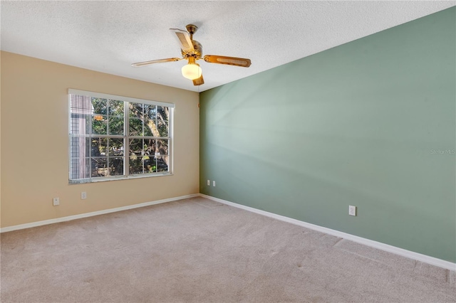 carpeted empty room featuring ceiling fan and a textured ceiling