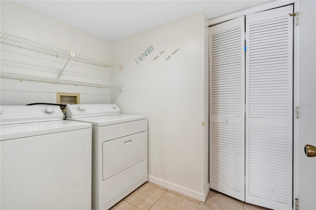 laundry room featuring washing machine and dryer and light tile patterned floors