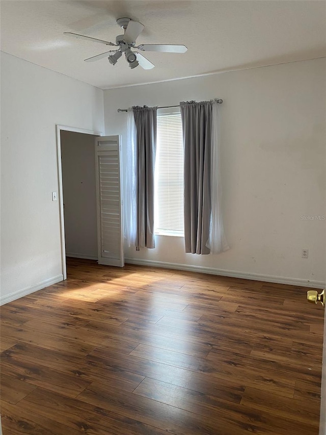 spare room featuring ceiling fan and dark hardwood / wood-style flooring