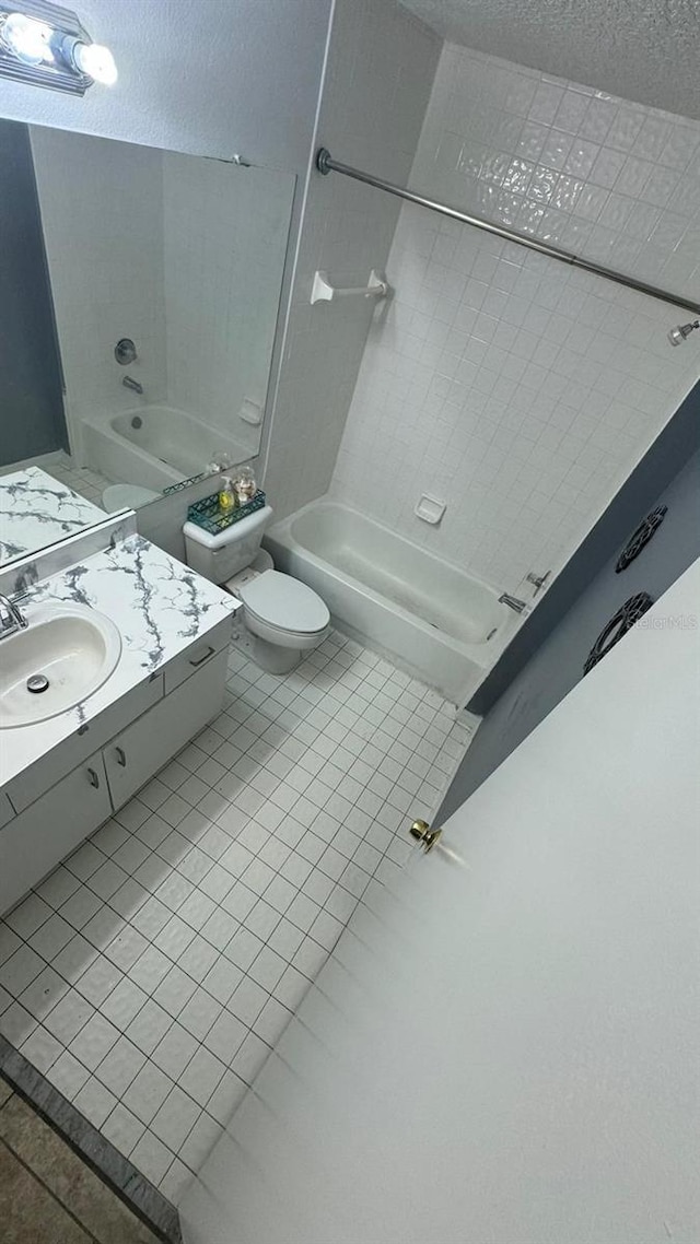 full bathroom featuring toilet, vanity, tiled shower / bath combo, and tile patterned floors