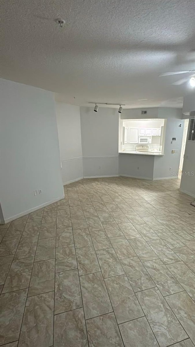 spare room featuring ceiling fan and a textured ceiling