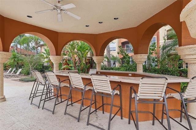 view of patio / terrace with ceiling fan and an outdoor bar