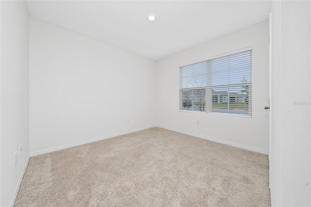 unfurnished room with light carpet