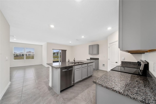 kitchen with gray cabinetry, dishwasher, stove, a kitchen island with sink, and sink