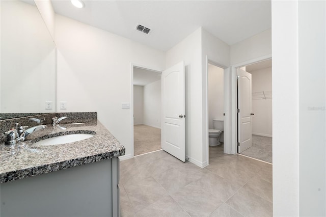 bathroom with tile patterned flooring, vanity, and toilet