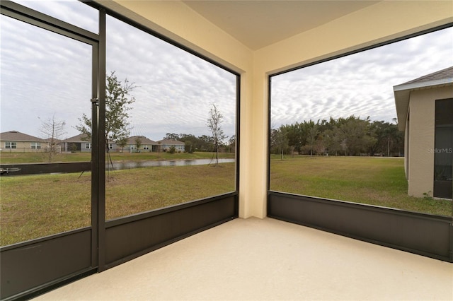 unfurnished sunroom featuring a water view