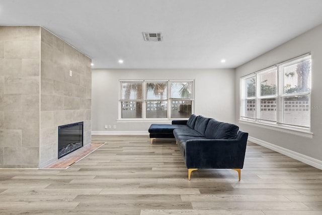 living room with light wood-type flooring and a fireplace