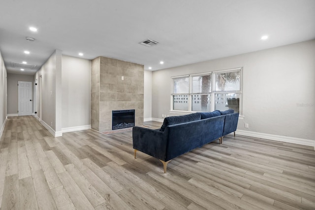 living room with a fireplace and light wood-type flooring