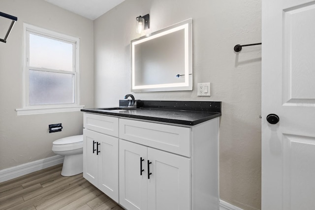 bathroom with vanity, toilet, and hardwood / wood-style floors