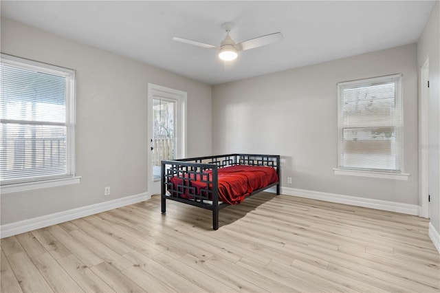 bedroom featuring multiple windows, ceiling fan, and light wood-type flooring