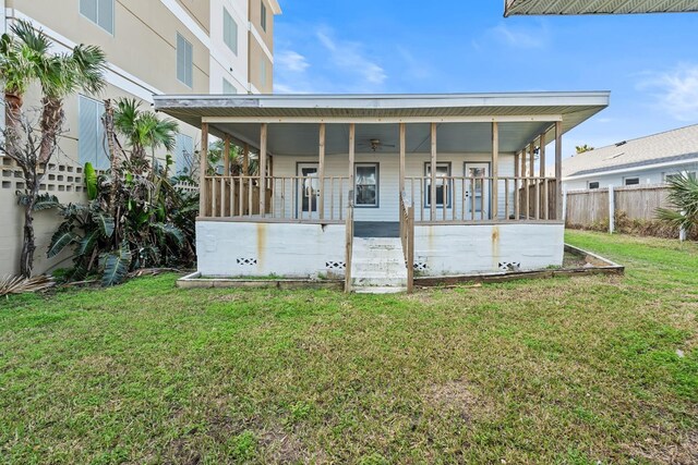 back of house featuring a yard and covered porch