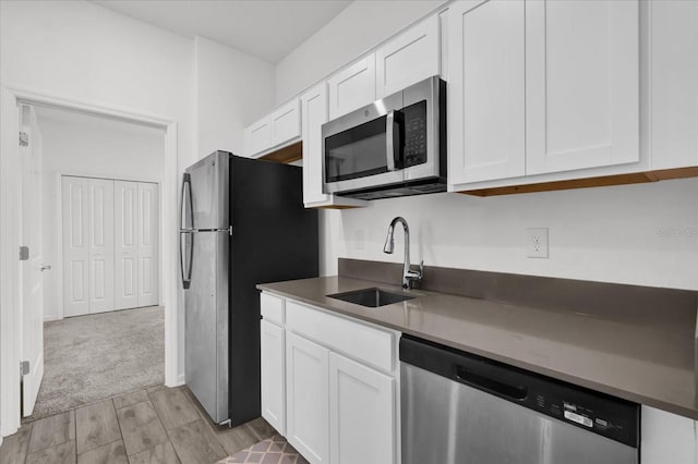 kitchen featuring stainless steel appliances, white cabinetry, and sink