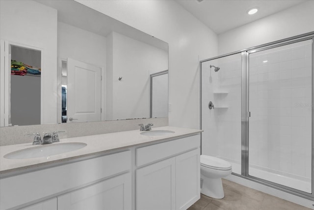 bathroom featuring tile patterned flooring, vanity, a shower with shower door, and toilet