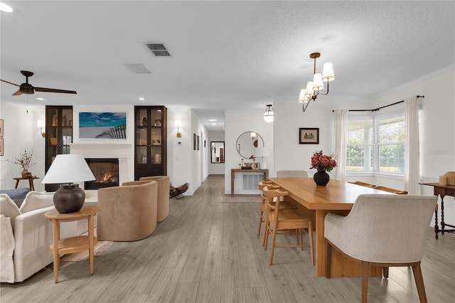 dining space featuring ceiling fan, light hardwood / wood-style floors, and a textured ceiling