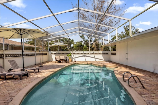 view of swimming pool featuring glass enclosure and a patio area