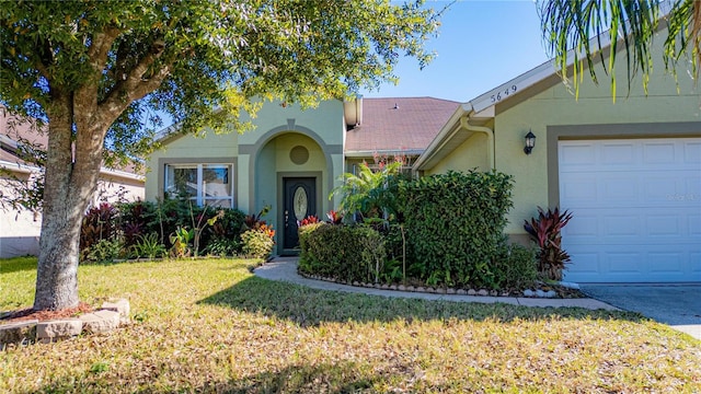 view of front of property featuring a garage and a front lawn