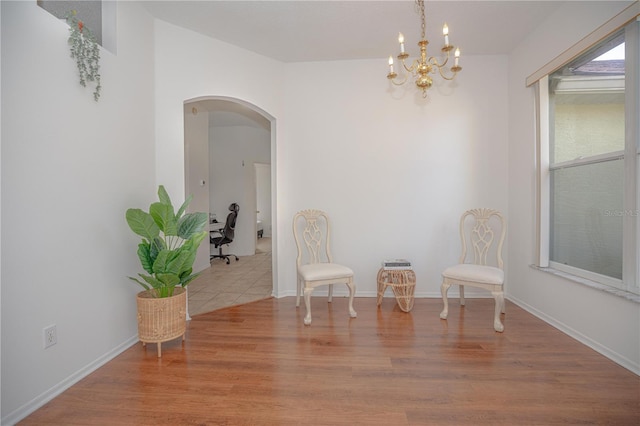 unfurnished room with an inviting chandelier and light hardwood / wood-style floors