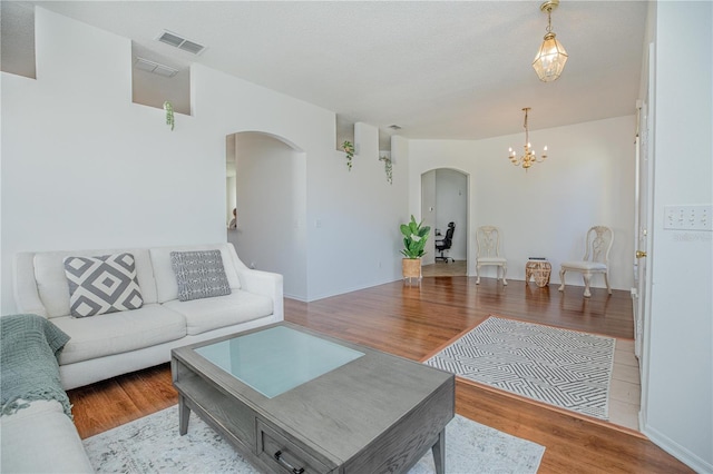 living room with light hardwood / wood-style flooring and an inviting chandelier