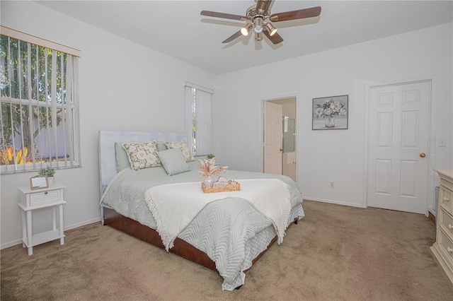 carpeted bedroom featuring ceiling fan and ensuite bath