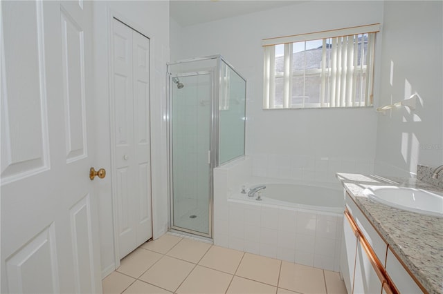 bathroom with tile patterned floors, vanity, and shower with separate bathtub