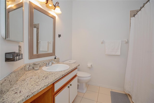 bathroom with toilet, vanity, and tile patterned flooring