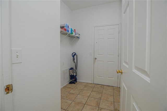 clothes washing area with light tile patterned floors