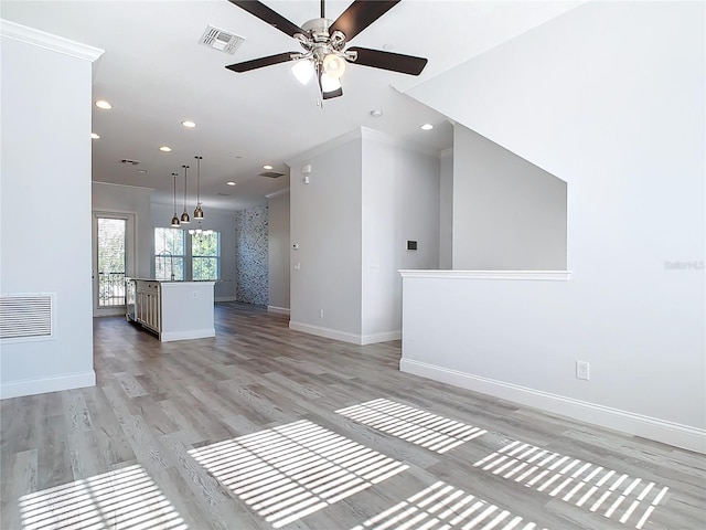 unfurnished living room featuring light hardwood / wood-style flooring, ceiling fan with notable chandelier, and ornamental molding