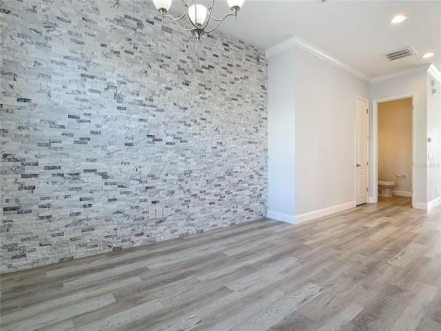 unfurnished room featuring hardwood / wood-style floors, ornamental molding, and a chandelier