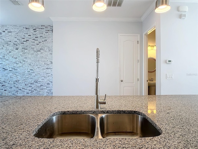 interior details featuring stone counters, sink, and ornamental molding