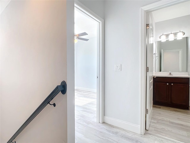 hallway with sink and light hardwood / wood-style floors