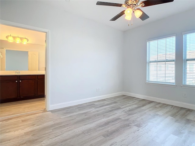 unfurnished room with ceiling fan, light hardwood / wood-style flooring, and sink