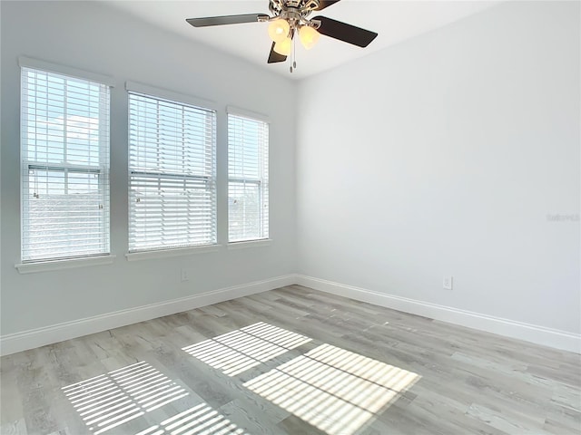 empty room featuring ceiling fan, a healthy amount of sunlight, and light hardwood / wood-style flooring