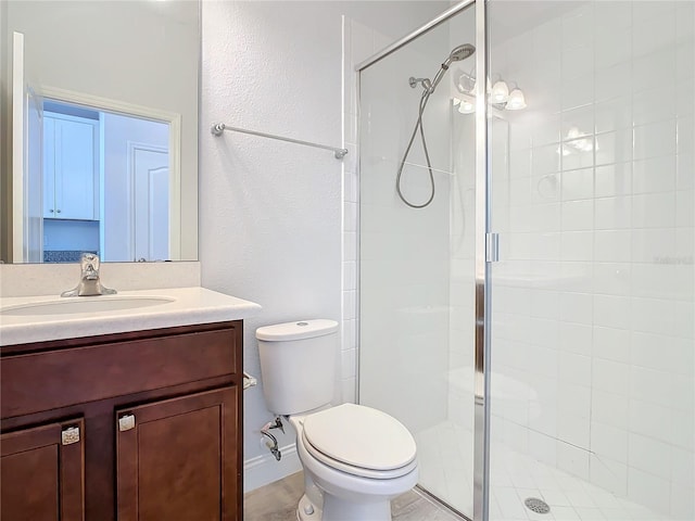 bathroom featuring vanity, toilet, and a shower with shower door