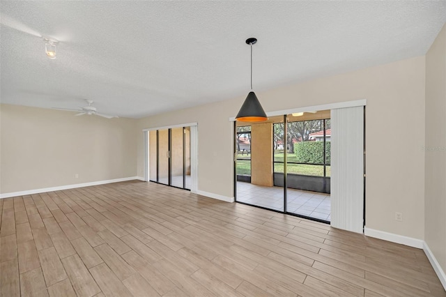 empty room featuring a textured ceiling, ceiling fan, and light hardwood / wood-style flooring