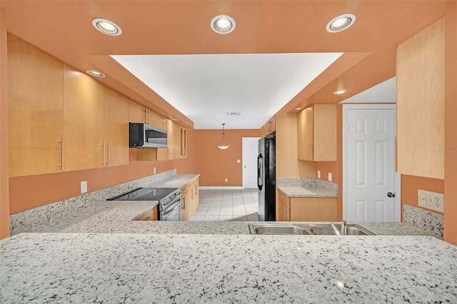 kitchen featuring black fridge, stainless steel range with electric cooktop, light brown cabinetry, and kitchen peninsula