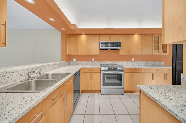 kitchen with sink, light tile patterned floors, stainless steel appliances, light stone counters, and light brown cabinets