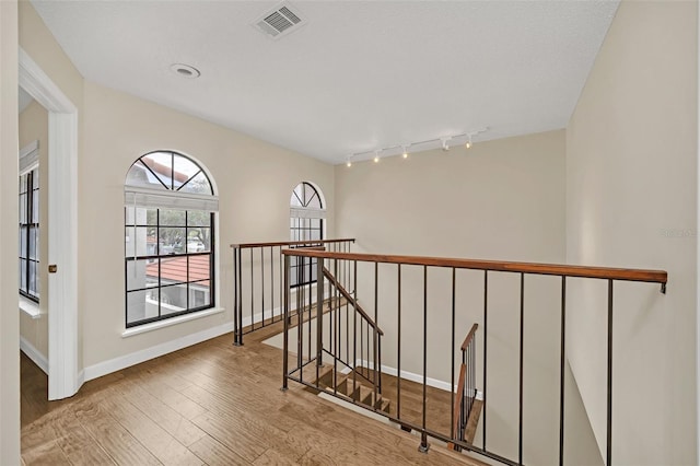 corridor featuring light hardwood / wood-style floors and rail lighting