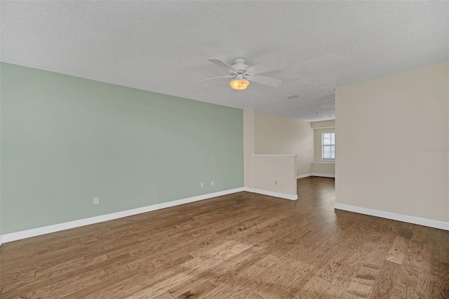 spare room featuring ceiling fan, wood-type flooring, and a textured ceiling