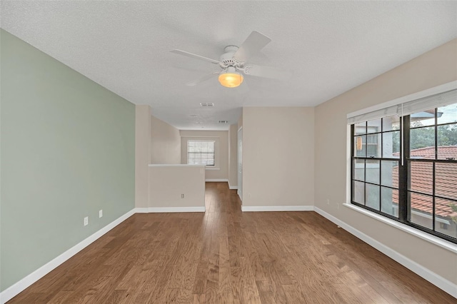 empty room featuring hardwood / wood-style flooring, a textured ceiling, and ceiling fan