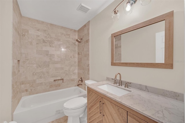 full bathroom featuring tiled shower / bath, vanity, and toilet