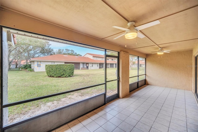 unfurnished sunroom featuring ceiling fan