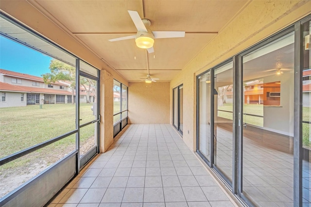 unfurnished sunroom with ceiling fan