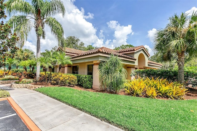 mediterranean / spanish house with a front lawn