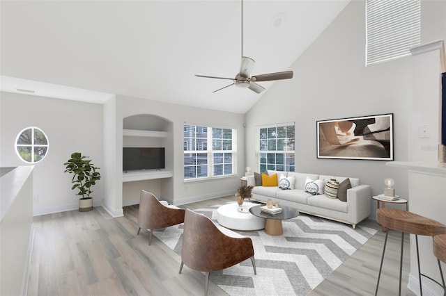 living room with light wood-type flooring, high vaulted ceiling, and ceiling fan