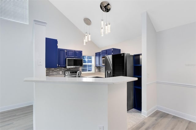 kitchen featuring hanging light fixtures, decorative backsplash, blue cabinetry, kitchen peninsula, and stainless steel appliances