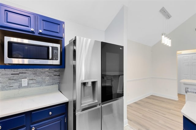 kitchen with blue cabinetry, stainless steel appliances, light hardwood / wood-style flooring, decorative light fixtures, and lofted ceiling