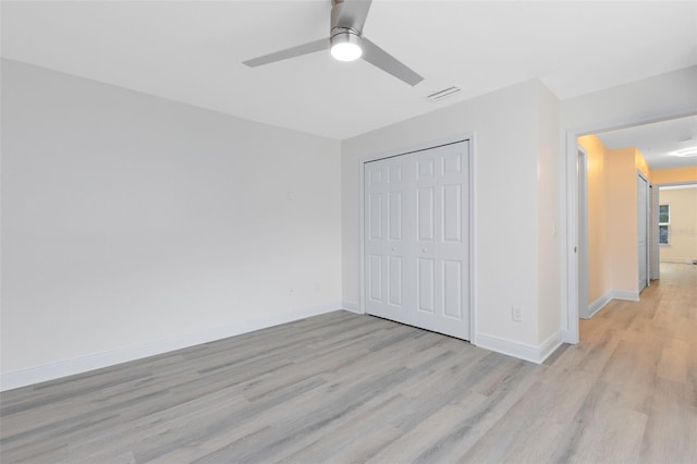 unfurnished bedroom featuring ceiling fan, light hardwood / wood-style flooring, and a closet